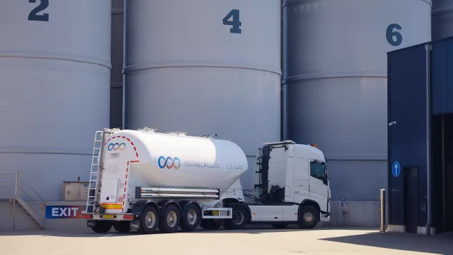 Looop vrachtwagen met silo's op de achtergrond